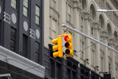 纽约市摩天大楼背景上的黄色交通灯。红色停车信号。