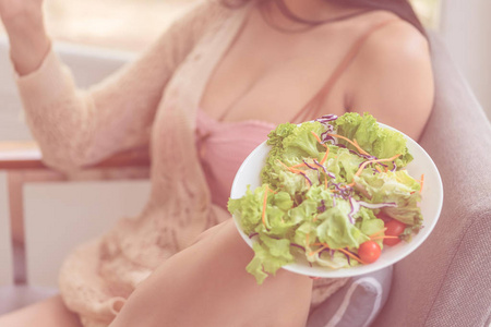 Healthy beautiful young woman is eating green salad for healthy 