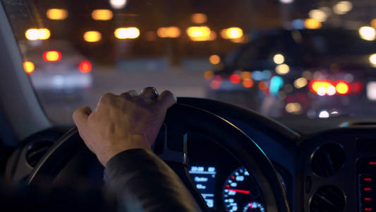 夜间驾驶手在方向盘上使用警告的图片.他开车.外面阳光明媚.