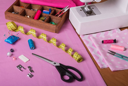 女裁缝的工作场所。彩色织物裁剪，缝纫配件，缝纫机