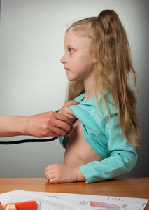 医生在家里用听诊器检查一个正在康复的金发小女孩