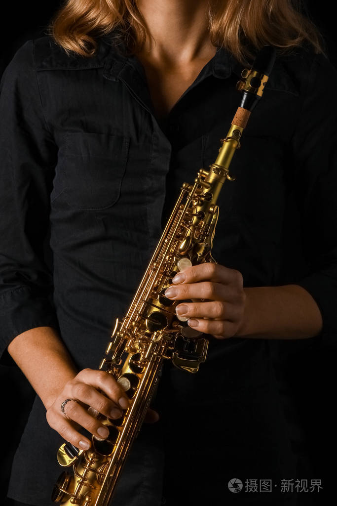 黑色背景下手持女高音萨克斯管