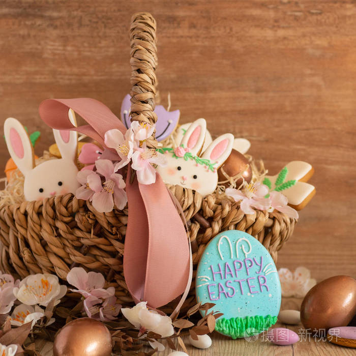 复活节快乐。木质背景的柳条篮子里五颜六色的彩色复活节饼干