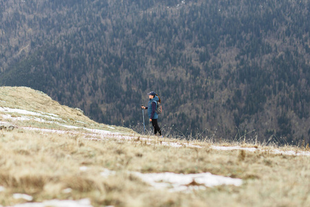 一个年轻的女旅行者爬上了一座被雪覆盖的山顶