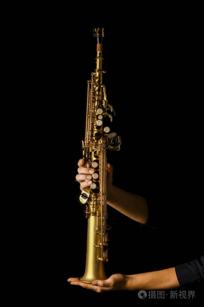 黑色背景下手持女高音萨克斯管