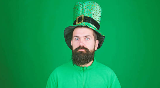 震惊和高兴。圣帕特里克节快乐。大胡子男人睁大眼睛庆祝圣帕特里克节。戴着妖精帽子和服装的时髦者。留着绿色胡子的爱尔兰人
