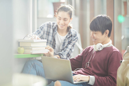 学生使用笔记本电脑和书本进行学习