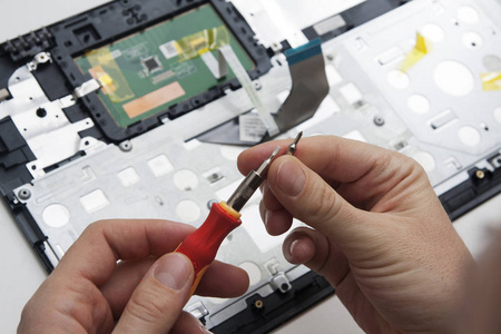 Male hands holding a screwdriver with nozzles on the background 