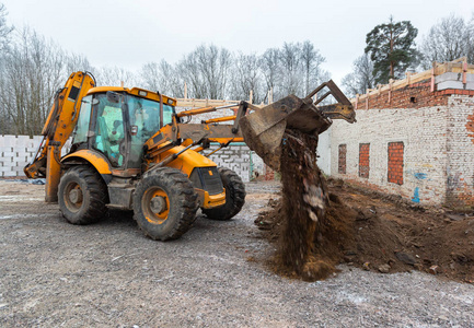 现代挖掘机在建筑工地上进行挖掘工作。作为工业机械一部分的挖掘地面的挖掘机斗的正面图