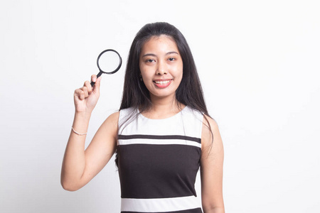 年轻的亚洲女人拿着放大镜。