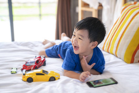 宝宝玩智能手机亚洲男孩玩玩具和智能手机照片