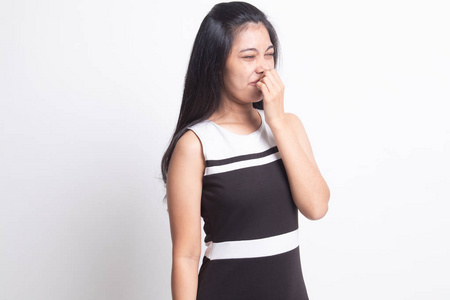 一个年轻的亚洲女人因为一股难闻的气味而捂住鼻子.照片