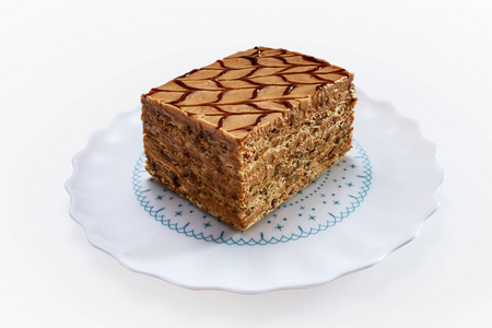 Cake piece with nuts and chocolate on a plate isolated on white 