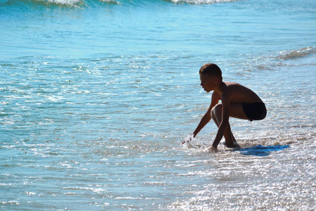 一个男孩在海里玩。去热带度假吧。