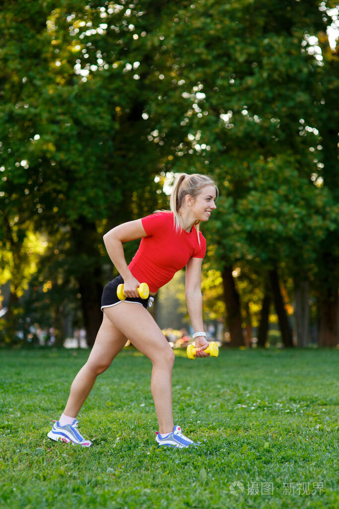 一个年轻女子喜欢户外运动金发女孩正在公园里训练自然