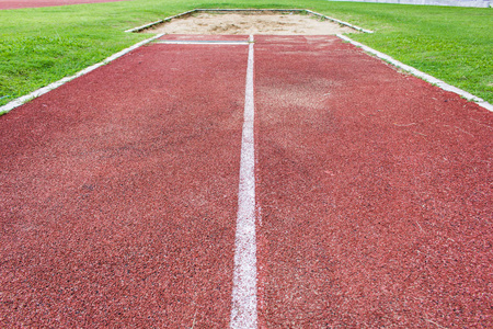 跳远板特写镜头女子三级跳远运动员学校田径跳远比赛的沙坑运动员跳远