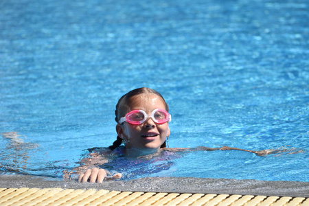 可爱的女孩喜欢在旅馆的游泳池里游泳。在水上度假的少年。游泳训练。和孩子们在海上度假。