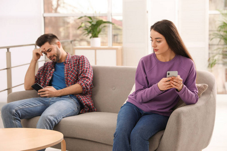 Young couple preferring smartphones over spending time together 