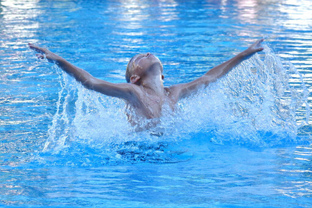 一个男孩在旅馆的游泳池里跳水.在度假村和孩子们一起玩得很开心.