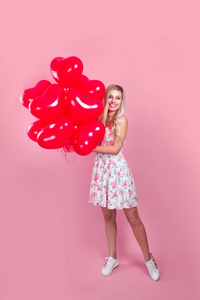 情人节女孩，粉色背景上有红色气球。