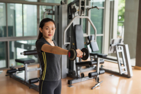 woman lift dumbbell weight training in gym 