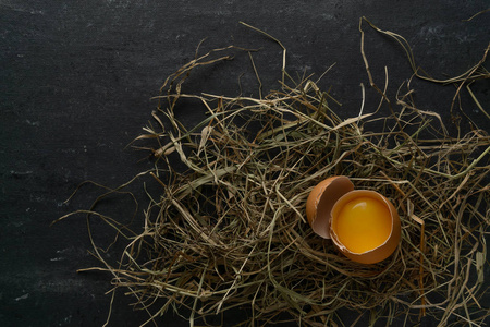 新鲜的农场鸡蛋躺在干草里，蛋黄在蛋黄里