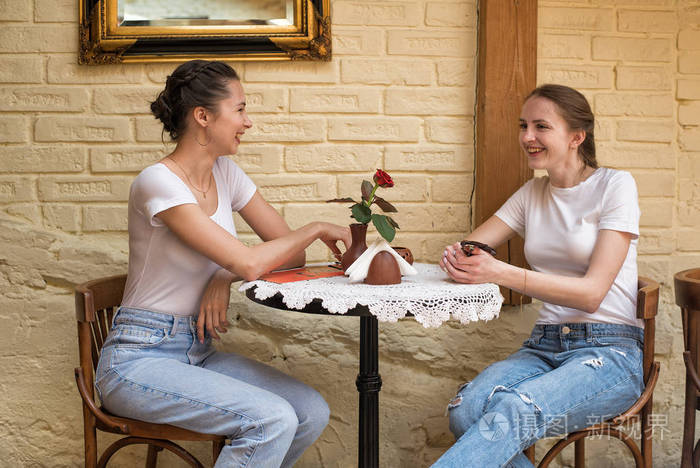两个女孩在圆桌上谈笑风生会见朋友闲聊