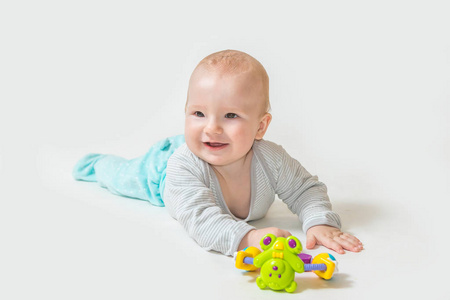 Smiling baby boy is showing a toy. 