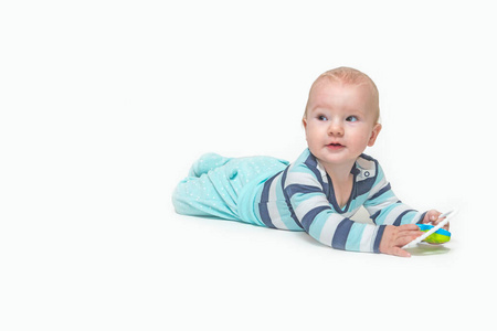 Cute baby boy is lying on white background holding a toy. 
