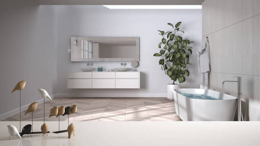 白色桌面或架子上有极简的鸟类装饰，小鸟小饰物覆盖模糊的现代白色浴室，带浴缸水槽浴缸植物，现代室内设计