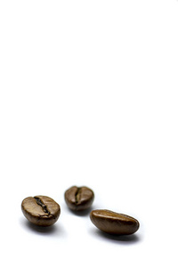 背景有三颗咖啡豆，烤咖啡豆有选择性地聚焦在白色背景上，空间为文字。