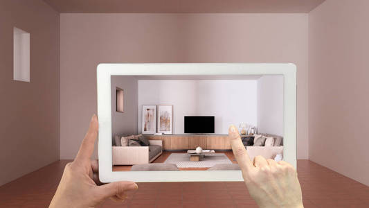 增强现实概念。带有AR应用程序的手持平板电脑，用于模拟家具和设计空室内的产品，陶土地板，舒适的客厅