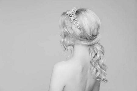 Hairstyle for blond wavy hair of a young girl. Back view. Black 