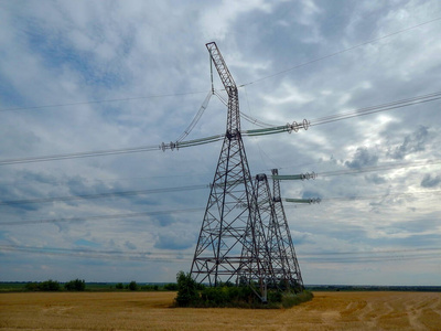高电压塔矗立在一个有电线的田野里