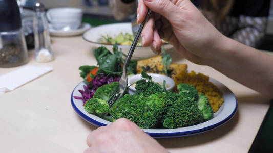 妇女在素食餐厅吃健康食品