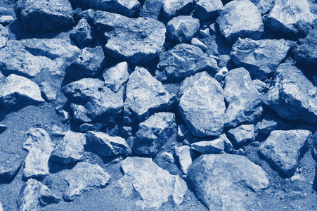 Yellow and gray cobblestones on a sandy beach on a bright sunny 