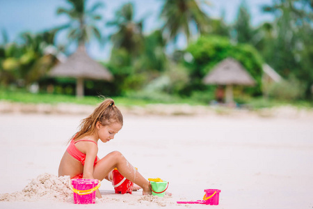 热带假期可爱的小女孩玩沙滩玩具