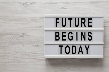 Future begins today words on a modern board on a white wooden 