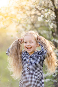 小金发女孩在春天公园玩得很开心。