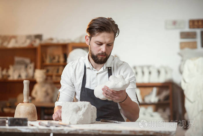 艺术家的手与石头雕刻家在创造性的工作场所在大气工作室。
