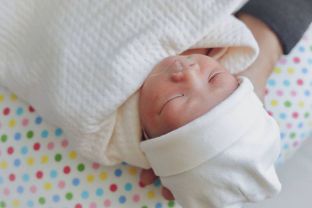 天真可爱的婴儿脸新生儿闭着眼睛睡在白色毯子里的童年