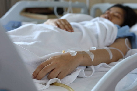 女患者卧床休息,手用静脉滴注生理盐水静脉注射治疗疾病纸上的worl