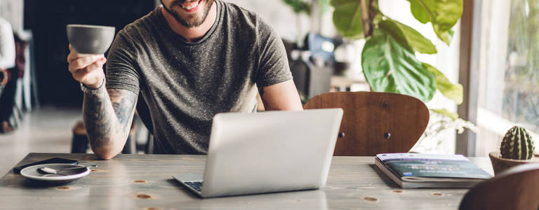 Handsome bearded hipster man use and looking at laptop computer 