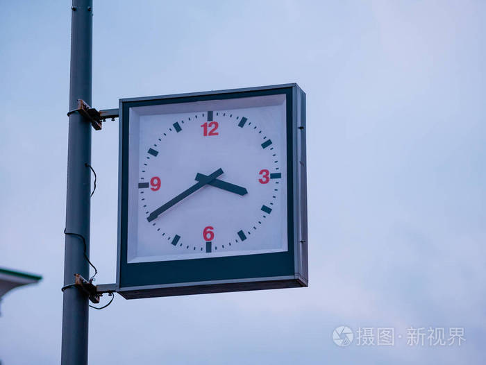 城市灯杆上的矩形盒式模拟时钟显示下午3:40的准确时间