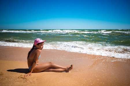 快乐美丽的小女孩在沙滩上休息