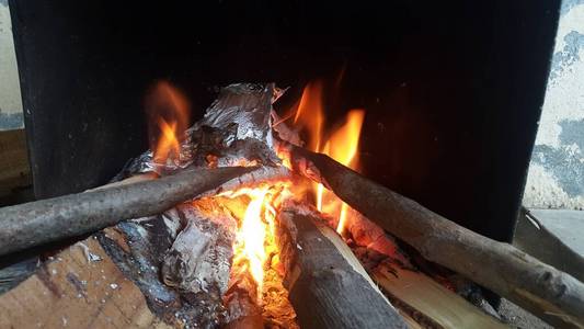 火盆里的原木上燃烧着余烬，燃烧着煤炭和熊熊燃烧的火焰。