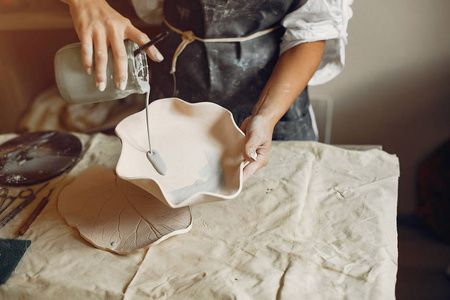 一个年轻的女人用陶器做盘子图片