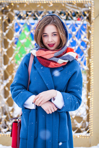 穿着蓝色外套的快乐小女孩在冬天的大街上摆姿势