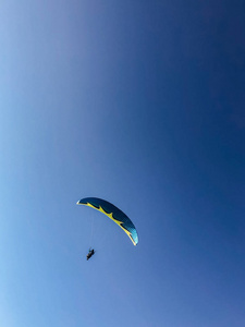 A man is engaged in paragliding. Parachute in the blue sky. 