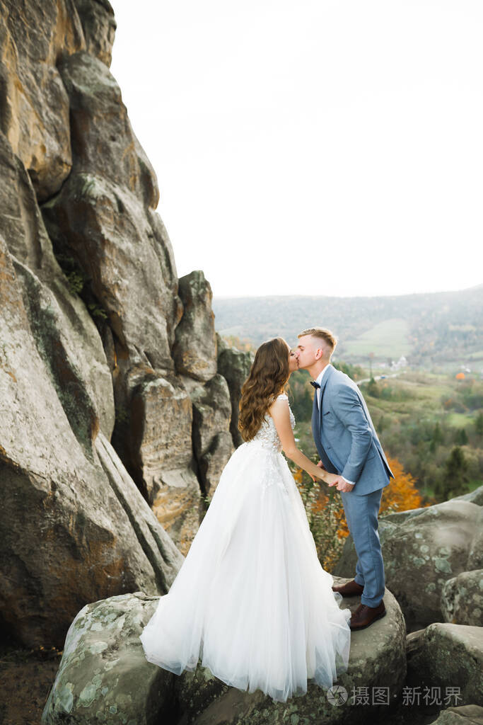 婚礼当天美丽的新郎新娘在户外拥抱亲吻